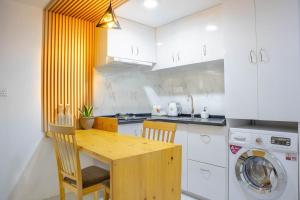 a kitchen with a wooden table and a washing machine at Aliran Dhangethi in Dhangethi