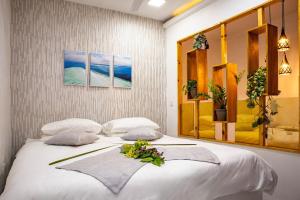 丹格迪Aliran Dhangethi的卧室里有一张白色的大床,床上摆着鲜花