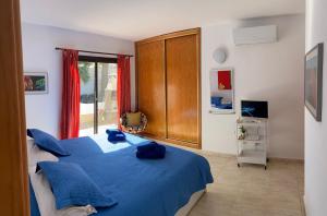 a bedroom with a blue bed and a window at Villa Primera in Playa Blanca
