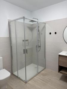 a glass shower in a bathroom with a toilet at Casa del Sol B in Arrieta +17 photos