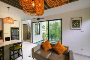 チャングーにあるGreenforest Anahata Villa Resortのオープンリビングルーム(ソファ、テーブル付)