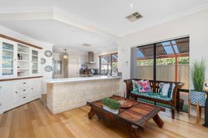 un soggiorno con un divano e un tavolo di Serenity and Style, Your Ashby Getaway Awaits a Wanneroo