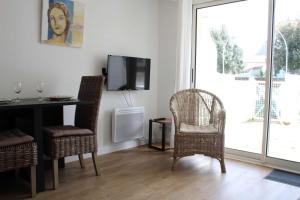 シャトライヨン・プラージュにあるAppt 2 pièces CHATELAILLON PLAGE - CL090-018のテーブルと椅子とテレビのあるリビングルーム