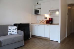 シャトライヨン・プラージュにあるAppt 2 pièces CHATELAILLON PLAGE - CL090-018のソファとキッチンのあるリビングルーム +5枚の写真