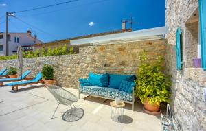 a patio with a blue couch and chairs on a stone wall at Lovely Home In Selina in Selina