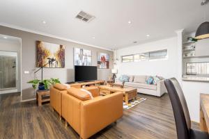 un salon avec un canapé et une télévision dans l'établissement Modern Family Friendly Retreat Home with Sunroom, à Clyde North