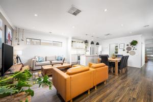 un salon avec un canapé et une table dans l'établissement Modern Family Friendly Retreat Home with Sunroom, à Clyde North