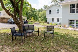 two benches sitting next to a tree in a yard at Cozy 2BR1BA apt in SilverSpeing in Silver Spring +11 photos