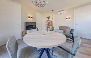 a dining room with a wooden table and chairs at 2 Bedroom Stunning Home In Afferden in Afferden