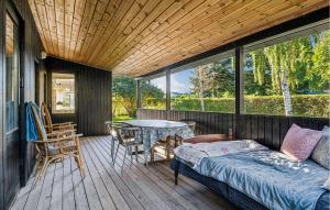 a porch with a bed and a table on a deck at 3 Bedroom Nice Home In Juelsminde in Juelsminde +17 photos