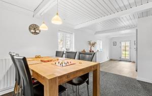 a dining room with a wooden table and chairs at 4 Bedroom Awesome Home In Grenaa in Grenå