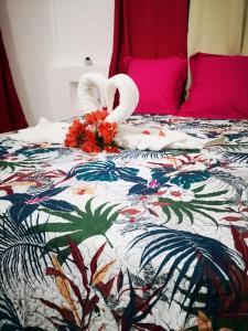 a bed with two swans and flowers on it at Villa confortable à Saint-François avec piscine in Saint-François