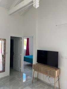 a living room with a flat screen tv on a wall at Villa confortable à Saint-François avec piscine in Saint-François +10 photos