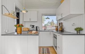 a white kitchen with white cabinets and a window at 3 Bedroom Gorgeous Home In Stege in Stege