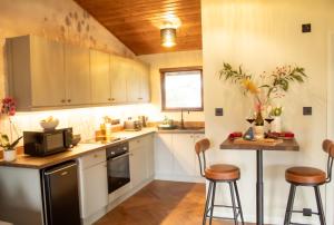 a kitchen with white cabinets and a wooden ceiling at Fraser Cottage in Kincraig