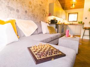a living room with a chess board on a couch at Fraser Cottage in Kincraig