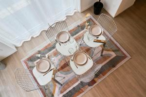 a table with four chairs on top of a rug at Appartement deux chambres & deux salles de bain in Villeneuve d'Ascq +18 photos