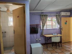 ein Zimmer mit einem Tisch und einem Fernseher in einem Zimmer in der Unterkunft MSA Hotel in Gaborone