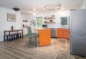 a kitchen with a table and a refrigerator at Sunflower Sanctuary Minutes to Fairbanks in Highland Park