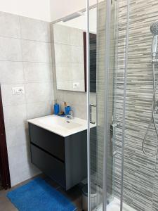 a bathroom with a sink and a glass shower at Isabel apulian apartment in Molfetta +7 photos
