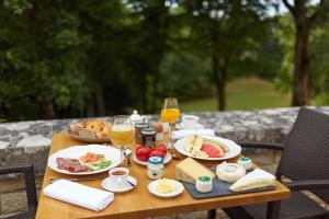 einen Holztisch mit Speisen und Gläsern Orangensaft in der Unterkunft Château Saint-Michel - Cercle des Grands Crus in Rully