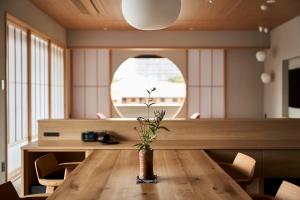 奈良Ryokan Asukasou at the entrancne of Nara park的一间用餐室,配有一张桌子和花瓶