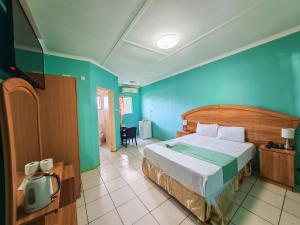 Un dormitorio con una cama y una pared azul. en MSA Hotel, en Gaborone