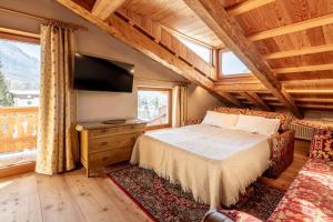 una camera da letto con un letto e una TV a schermo piatto di CORTINA Lodge a Cortina dʼAmpezzo