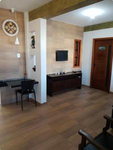 a living room with a table and a television at Casa Amar in Barra dos Coqueiros