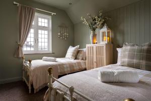 een slaapkamer met twee bedden en een raam bij Broadway Country Chic Cottage in Broadway