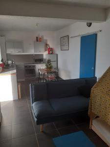 a living room with a couch and a kitchen at tite Caz a nou in Saint-Paul
