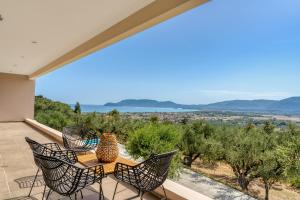 a patio with chairs and a table with a view at Astarte Villas - Pearl Private Villa with Pool in Kalamaki