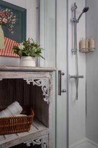 een deur met een vaas met bloemen op een kast bij Broadway Country Chic Cottage in Broadway +54 foto's