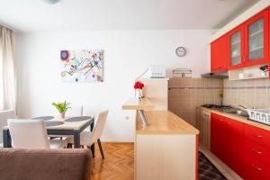 a kitchen with red cabinets and a table in a kitchen at Antares in Bjelovar
