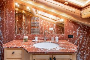 bagno con lavandino e parete in marmo rosso di CORTINA Lodge a Cortina dʼAmpezzo Altre 31 foto
