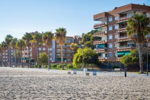 een groot appartementencomplex met palmbomen op de achtergrond bij AT103 Pins Beachfront complex, beach view in Torredembarra