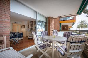 een eetkamer en woonkamer met een tafel en stoelen bij AT103 Pins Beachfront complex, beach view in Torredembarra