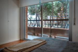 een slaapkamer met een groot raam en een groot bed bij AT103 Pins Beachfront complex, beach view in Torredembarra +40 foto's
