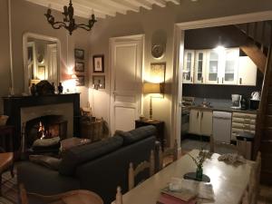 Saint-Paterne-RacanにあるGîte du château d'Hodebertのソファと暖炉のあるリビングルーム