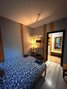 a bedroom with a bed with a blue and white comforter at visitDINAMO in Kandava