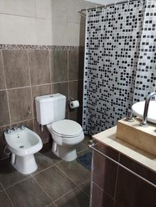 a bathroom with a toilet and a sink at Casa Poetas in Villa Nueva +4 photos