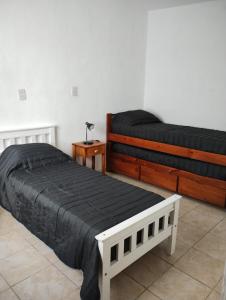 a bedroom with two beds and a table with a lamp at Casa Poetas in Villa Nueva