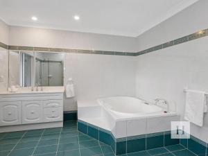 a white bathroom with a tub and a sink at Angels Little Haven in Cams Wharf +23 photos