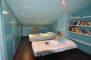 two beds in a room with a book shelf at RNET - Apartments Roses Centre in Roses