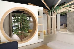 a living room with a circular mirror and a plant at Aparthotel Nou Vielha in Vielha
