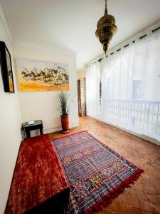 a living room with a rug and a large window at Riad FARASHA & Pool-Rooftop View in Marrakesh