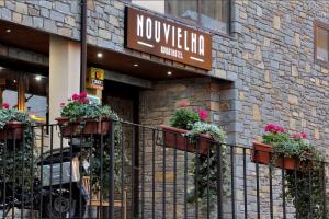 a restaurant with flowerpots on the front of a building at Aparthotel Nou Vielha in Vielha
