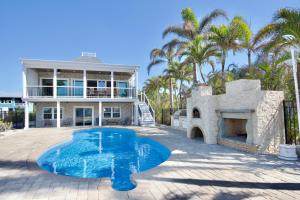 フォートマイヤーズビーチにあるBayview Sunset Getaway by Sun Palace Vacationsの家の前にプールがある家