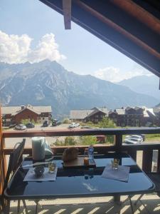 d'une table sur un balcon avec vue sur la montagne. dans l'établissement Appartement 4 personnes Puy Saint Vincent 1800, à Puy-Saint-Vincent