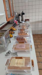 a counter with several plastic containers of food on it at Hotel Veleiro in Florianópolis